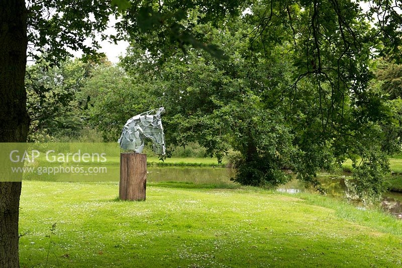 Une sculpture de tête de cheval sur un socle en bois, par l'artiste James Wild.