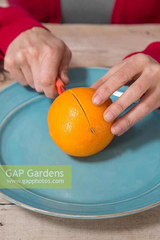 Couper l'orange en deux sur une assiette