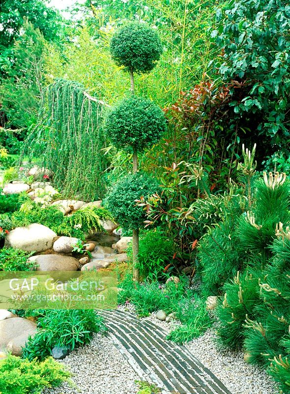 Un chemin d'ardoise et de gravier mène à travers le jardin japonais. Chelsea Flower Show 2002: Le monde merveilleux des koi. Conception: Roy Day et Steve Hickling