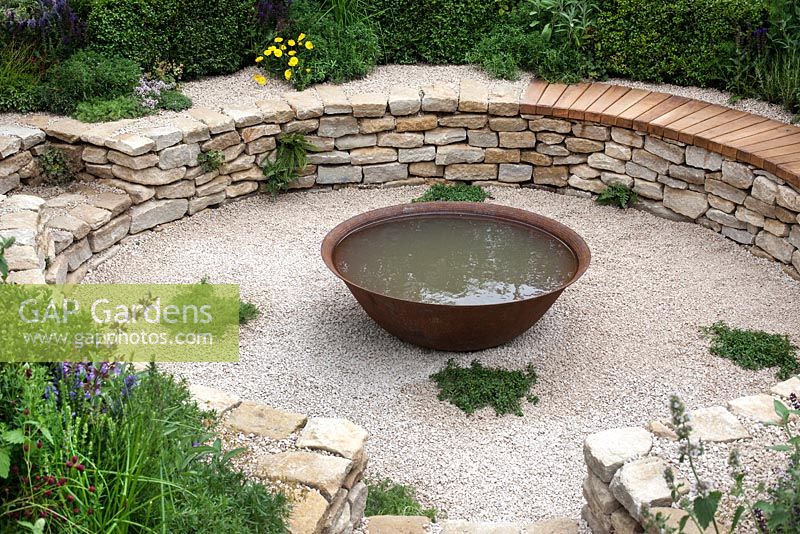 Coin salon en contrebas avec élément d'eau construit à partir de murs en pierre sèche dans le jardin 'Time is a Healer' au RHS Tatton Flower Show 2015