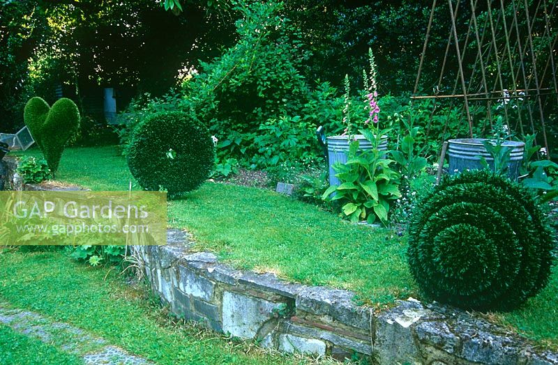 Astrotuf en spirale, disque et coeur par la sculpteur Lucy Strachan, positionné à côté du potager dans son jardin