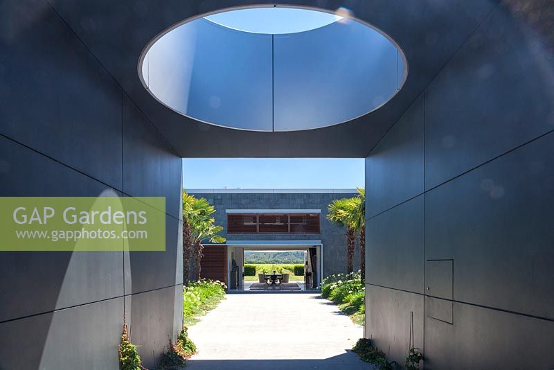 Oculus jette une ombre et une vue à travers la maison moderne sur les vignobles au-delà au jardin Bhudevi Estate, Marlborough, Nouvelle-Zélande.