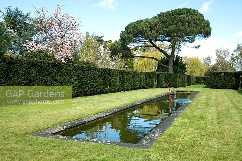Étang long et étroit avec fontaine d'eau sculptée - Dunsborough Park Gardens, Ripley, Surrey