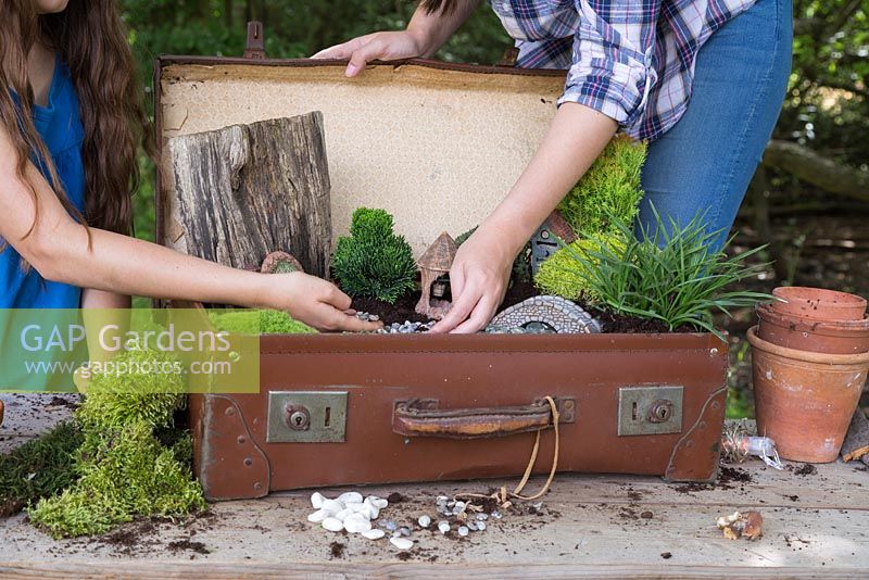 Ajoutez un paillis de gravier au compost une fois que les figurines et les plantes sont en place