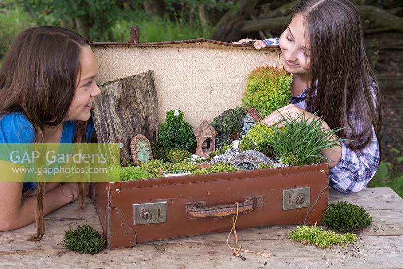 Deux filles satisfaites de leur projet de jardin miniature terminé