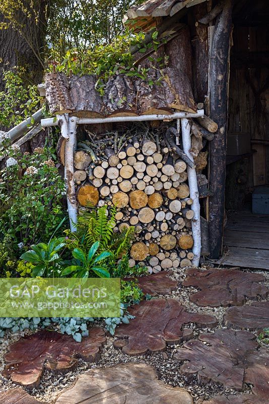 Magasin de billes et pierres de gué en troncs d'arbres. Le jardin du bûcheron, RHS Malvern Spring Festival 2016. Conception: Mark Walker