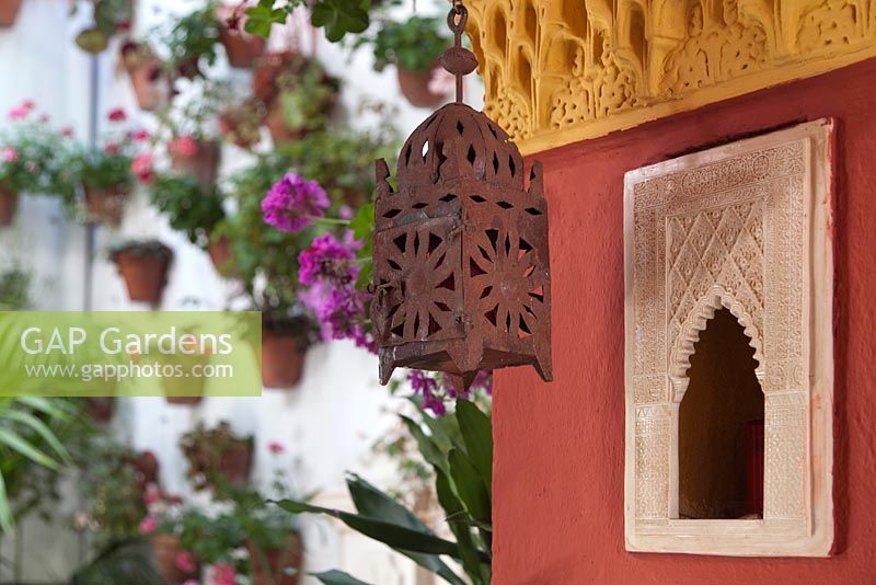 Lanterne de style marocain sur mur de plâtre coloré avec des pélargoniums en arrière-plan, Cordoue, Espagne