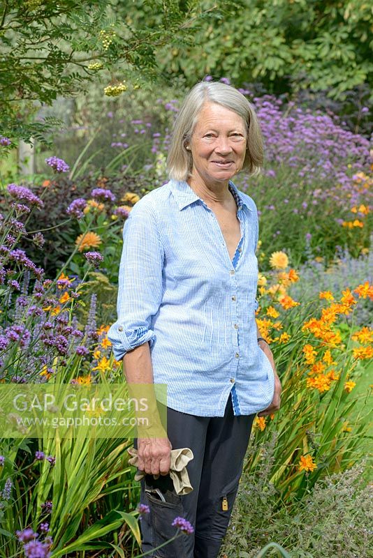 Susie Pasley-Tyler à côté du parterre orange, violet et bleu qui culmine en septembre, au fond du jardin.