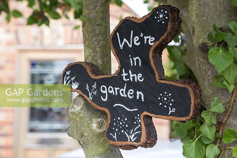 Tranche de chêne peinte et décorée pour afficher 'We ' re in the garden'