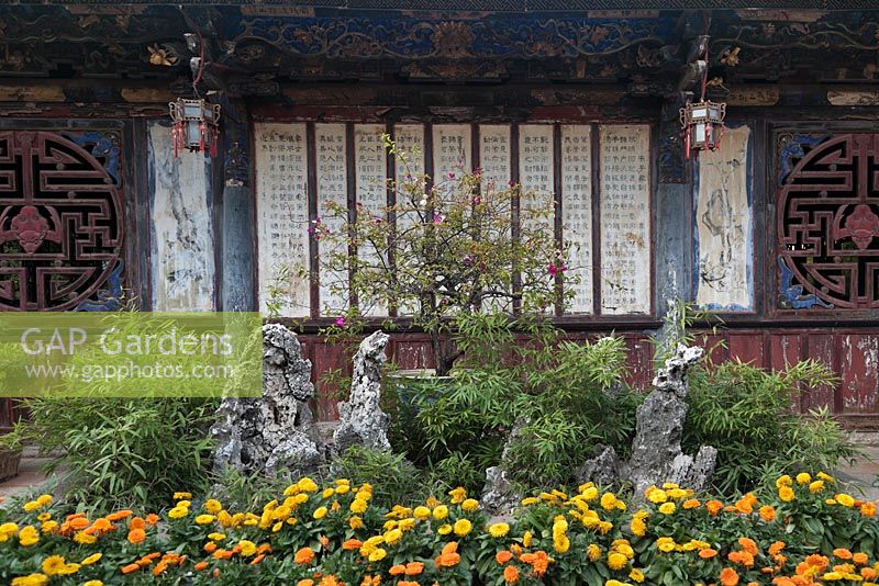 Jardin de la cour chinoise avec des roches sculpturales, des bambous, des murs et des fenêtres décoratives peintes - Jardin familial Zhu, ancienne ville de Jianshui, Chine