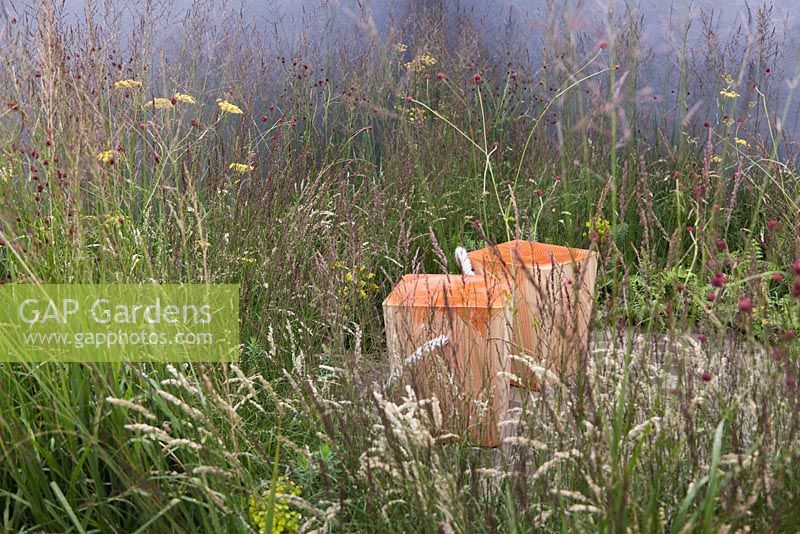 Une plantation naturaliste d'herbes et de vivaces entoure un coin salon pavé en pierre - juillet, 'A Quiet Corner' au RHS Tatton Flower Show 2015
