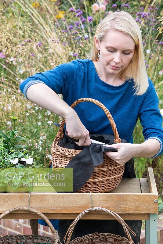 Étape par étape, planter des paniers d'automne: le tissu perméable est coupé au niveau du bord supérieur du panier.