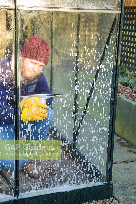 Nettoyage des vitres sales d'un petit patio à effet de serre