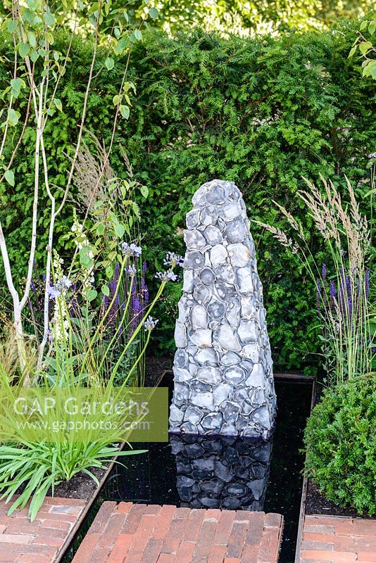 Sculpture en silex au bout de l'eau, Summer's Streetscape's Sussex Garden, RHS Hampton Court Palace Flower Show 2016. Conçu par Will Williams