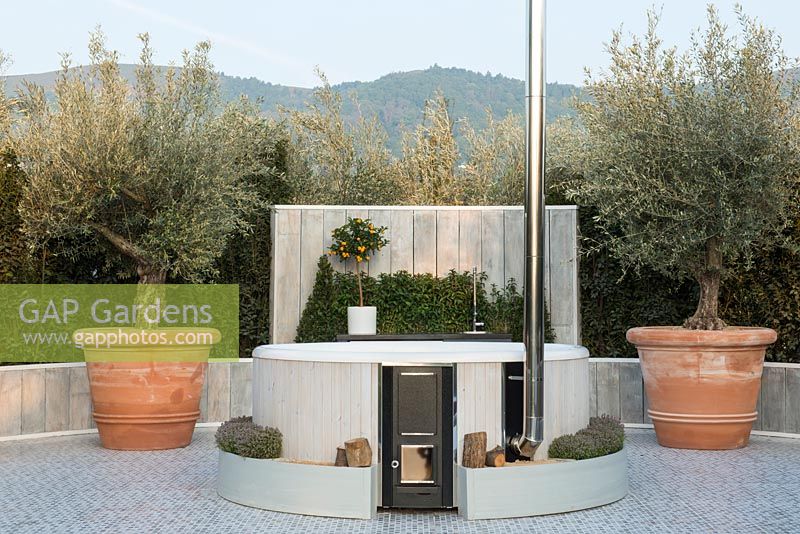 Spa chauffé par un poêle à bois, des oliviers dans des jardinières en terre cuite - The Retreat, RHS Malvern Spring Festival 2017 - Design: Villaggio Verde