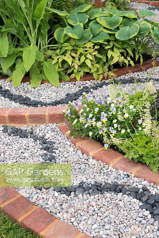 Détail de gravier avec parterres de fleurs bordés de briques - Spa Garden - Je suis les eaux et le vent, RHS Malvern Spring Festival 2017 - Conception: Annette Baines-Stiller