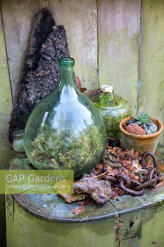 Bouteille en verre, pot en terre cuite et autres objets trouvés arrangés à Charlotte et au jardin de Donald Molesworth, Kent, UK.