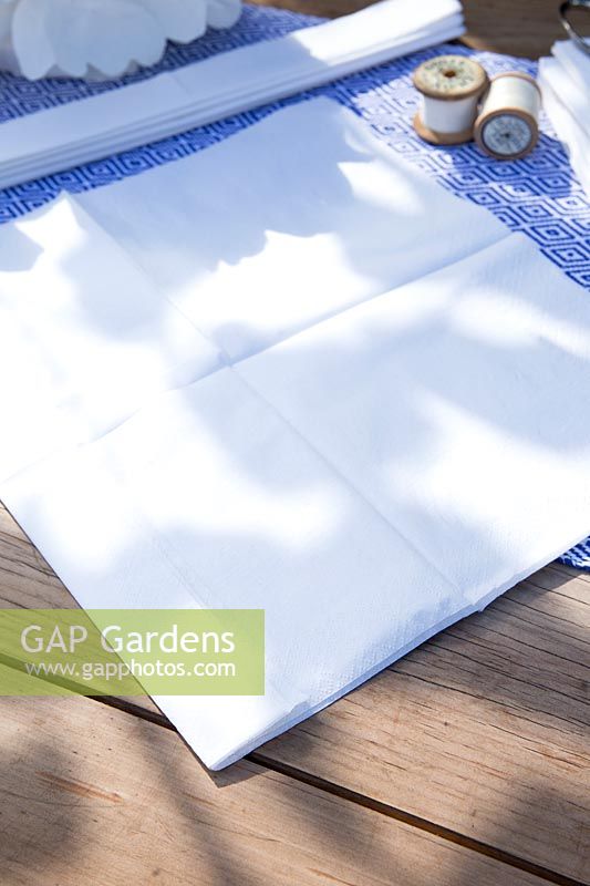Faire un pompon en papier à partir de serviettes. Prenez 3 autres serviettes et répétez le processus - vous voulez vous retrouver avec 2 bandes pliées finies