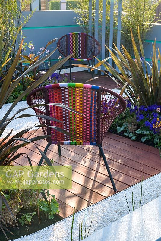 Chaises de jardin colorées avec plantation de bambou, de phormium et de Pericallis x hybrida 'Senetti Deep Blue' - Ocean Garden, RHS Malvern Spring Festival 2017
