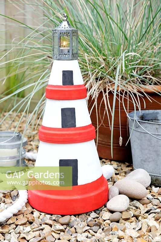 Fabrication d'une lanterne de phare de jardin avec des pots en terre cuite - ajoutez une petite lanterne ou un pot de confiture sur le dessus avec une bougie chauffe-plat