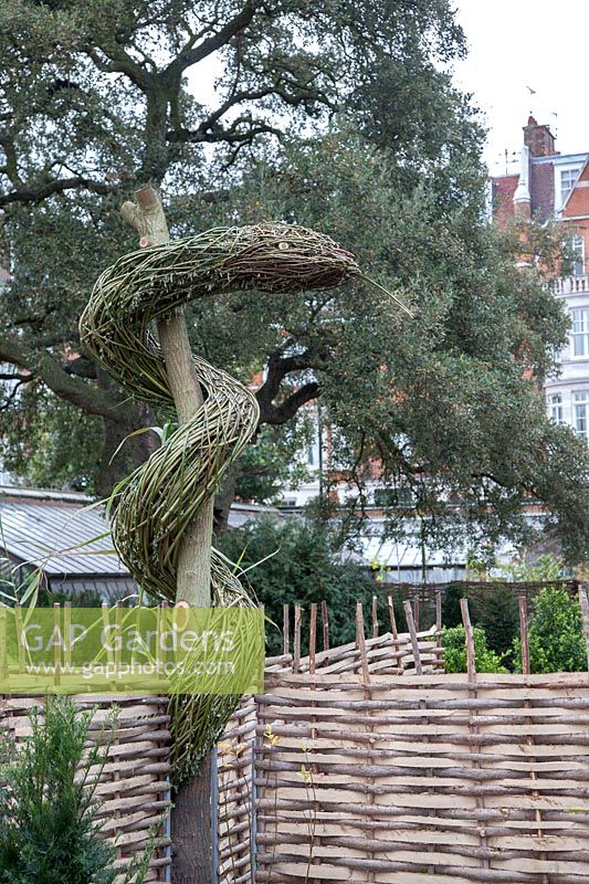 Sculpture de saule tressé au Chelsea Physic Garden, Londres, représentant 'La verge d'Asclépios', traditionnellement représentée comme un serpent enlacé autour d'un bâton