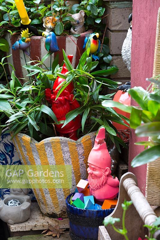 Nains de jardin et pots en béton rétro avec oiseaux jouets, juin.