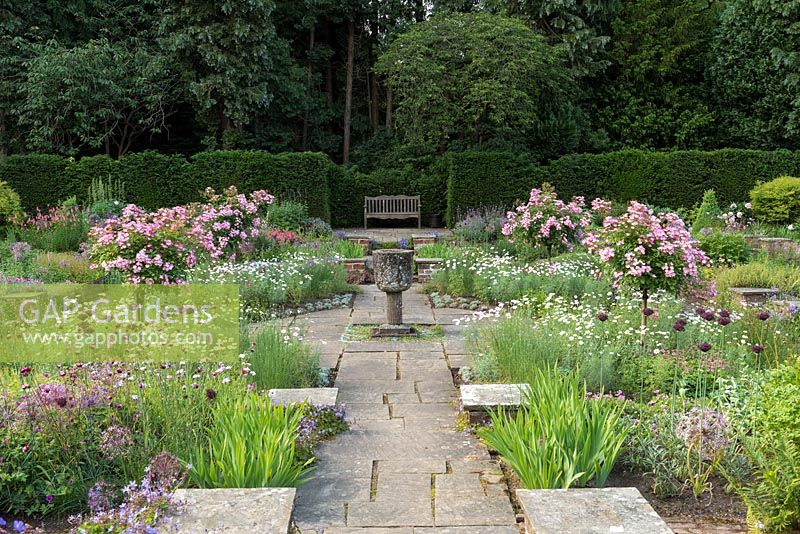 Jardin de Sylvia à Newby Hall, une disposition formelle et submergée de parterres de fleurs avec un broyeur de maïs en pierre byzantine.