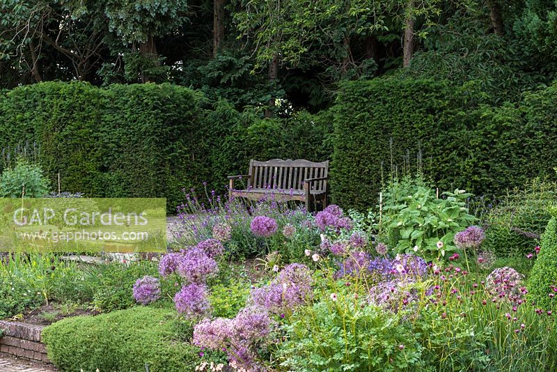 Le jardin de Sylvia à Newby Hall, un banc installé dans une haie d'ifs surplombe la disposition formelle et enfoncée des parterres de fleurs.