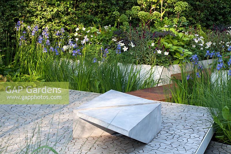 Un jardin moderne avec banquette en béton et Iris. RHS Chelsea Flower Show 2014. Conception Hugo Bugg. Gagnant de la médaille d'or