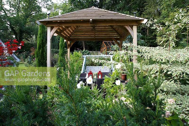 Le jardin de Jackie Healy près de Chepstow. Jardin au début de l'automne. Table de salle à manger de style japonais en 'pergola' dans le patio