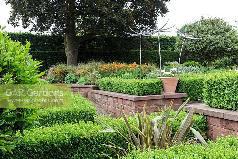 Mitton Manor, Staffordshire. Parterre de jardin formel avec des sculptures en verre 'Suncatcher' de Neil Wilkin