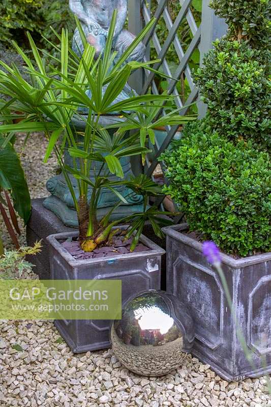 David Grays Garden à Warmley, Bristol, Royaume-Uni. très petit jardin de ville avec de nombreux pots, statues. plantes exotiques en pot