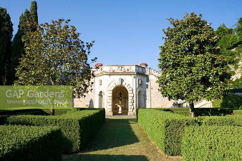 Villa La Foce, Toscane, Italie. Grand jardin avec couverture de boîte coupée topiaire et vue sur la campagne toscane