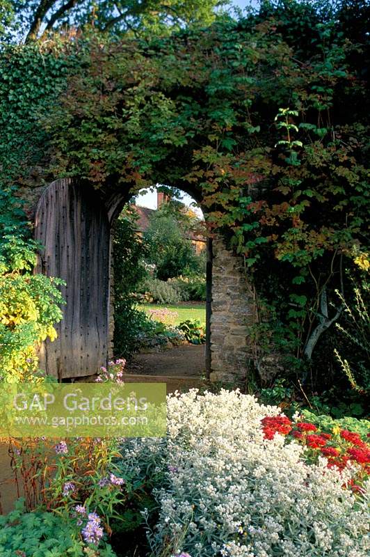 Munstead Wood Surrey Gertrude Jekyll Porte en mur de pierre Jardin d'été avec vue sur maison