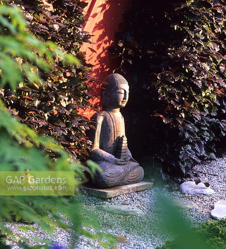 Tilford Cottage Surrey statue de Bouddha en pierre face à l'est dans le jardin japonais