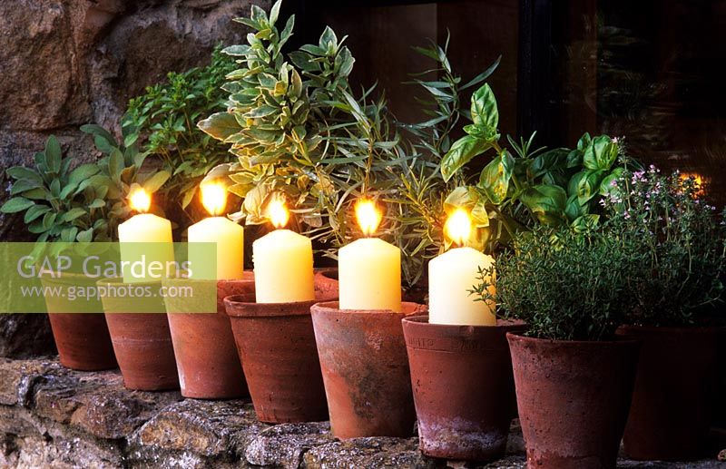 Les Oast Houses Hampshire Garden Lighting Candles dans des pots en terre cuite sur le rebord de la fenêtre avec des herbes en pot