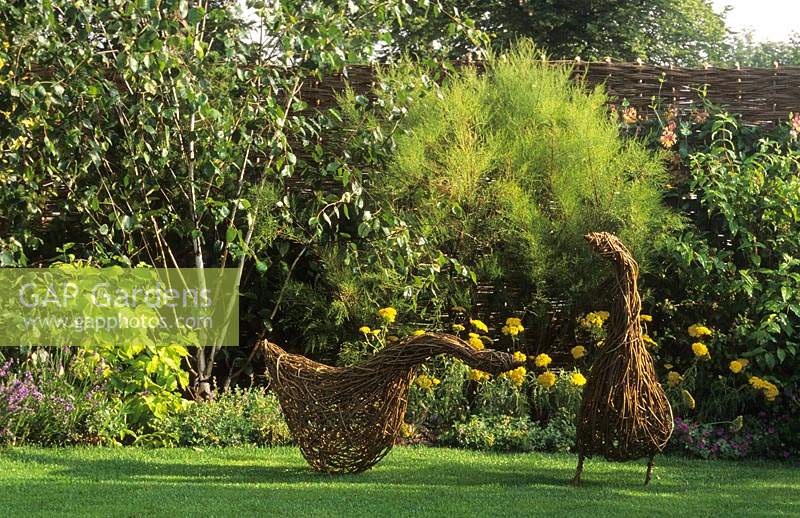Oies sculpturales de jardin tissées à partir de noisetiers de saule sur pelouse