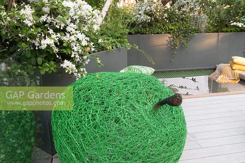 Sculpture de pomme verte tissée. Le Jardin de bienfaisance Greenfingers. Conçu par Kate Gould Gardens, parrainé par Greenfingers Charity, RHS Chelsea Flower Show, 2019.