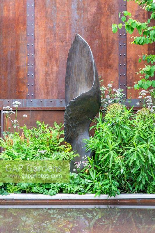 Sculpture dans le jardin Wedgwood contre un mur en métal rouillé. Conception: Jo Thompson. Commanditaire: Wedgwood