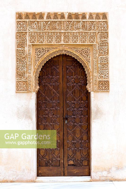 Porte en bois avec artésonados encadrée avec écriture arabe. Patio de Arrayanes,, Palacios Nazaries - Palais Nasrides, l'Alhambra, Grenade.