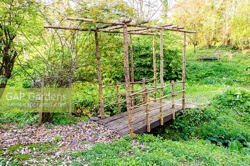 Pont rustique sur ruisseau dans le jardin de la vallée. Ferme Brilley Court, Whitney-on-Wye, Herefordshire