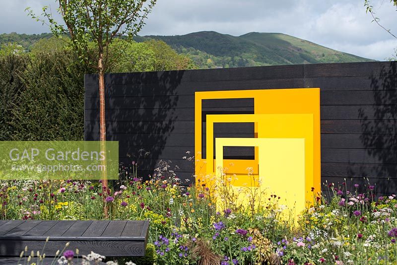 Panneaux sculpturaux en acier jaune avec fond de clôture noire - 'Urban Oasis', RHS Malvern Spring Festival, 2018.