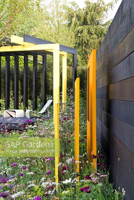 Vue latérale des panneaux sculpturaux en acier jaune dans le jardin 'Urban Oasis', RHS Malvern Spring Festival, 2018.
