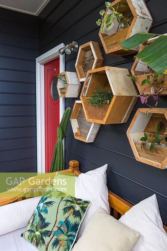Un mur de jardinières hexagonales en bois affichant une collection de plantes.