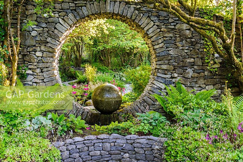 Fenêtre de la lune dans un mur en pierre avec élément en béton coulé avec plantation d'ombre. Fanore, Irlande