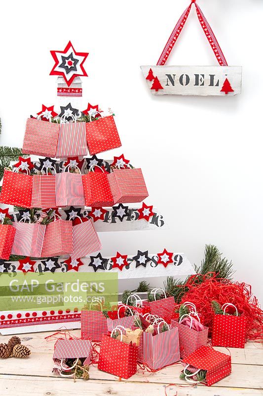 Sapin de Noël en palette de l'Avent avec sacs en papier et cadeaux festifs