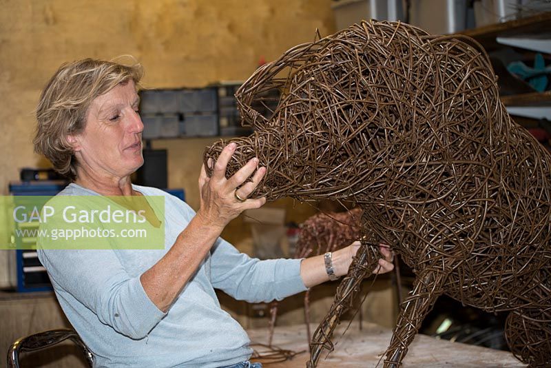 Helen Colletta travaillant sur une sculpture de cochon de saule dans son atelier, Suffolk