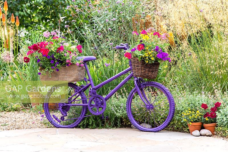 Vélo enfant peint avec des paniers de plantes annuelles colorées