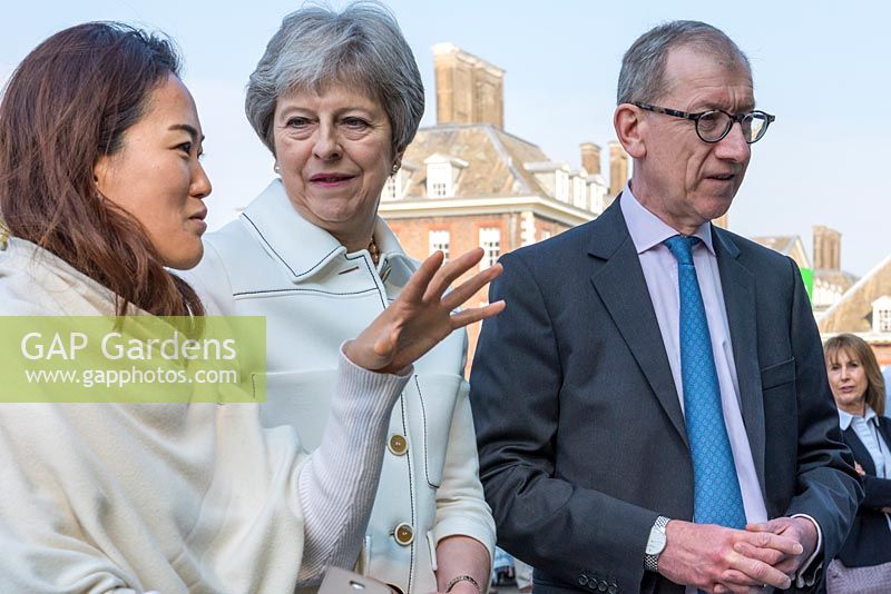 La Première ministre Theresa May et son mari Philip discutent avec le jardinier Hay-Joung Hwang au Chelsea Flower Show 2018.