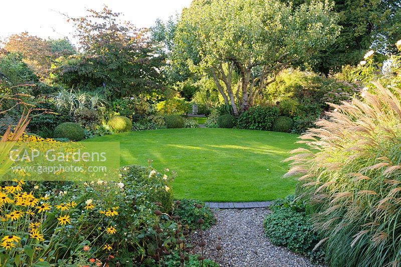Pelouse circulaire avec parterres de plantes herbacées vivaces et de graminées - Shropshire, Royaume-Uni
